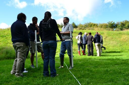 Several individuals are being instructed in how to perform geophysical survey by Duncan Hale