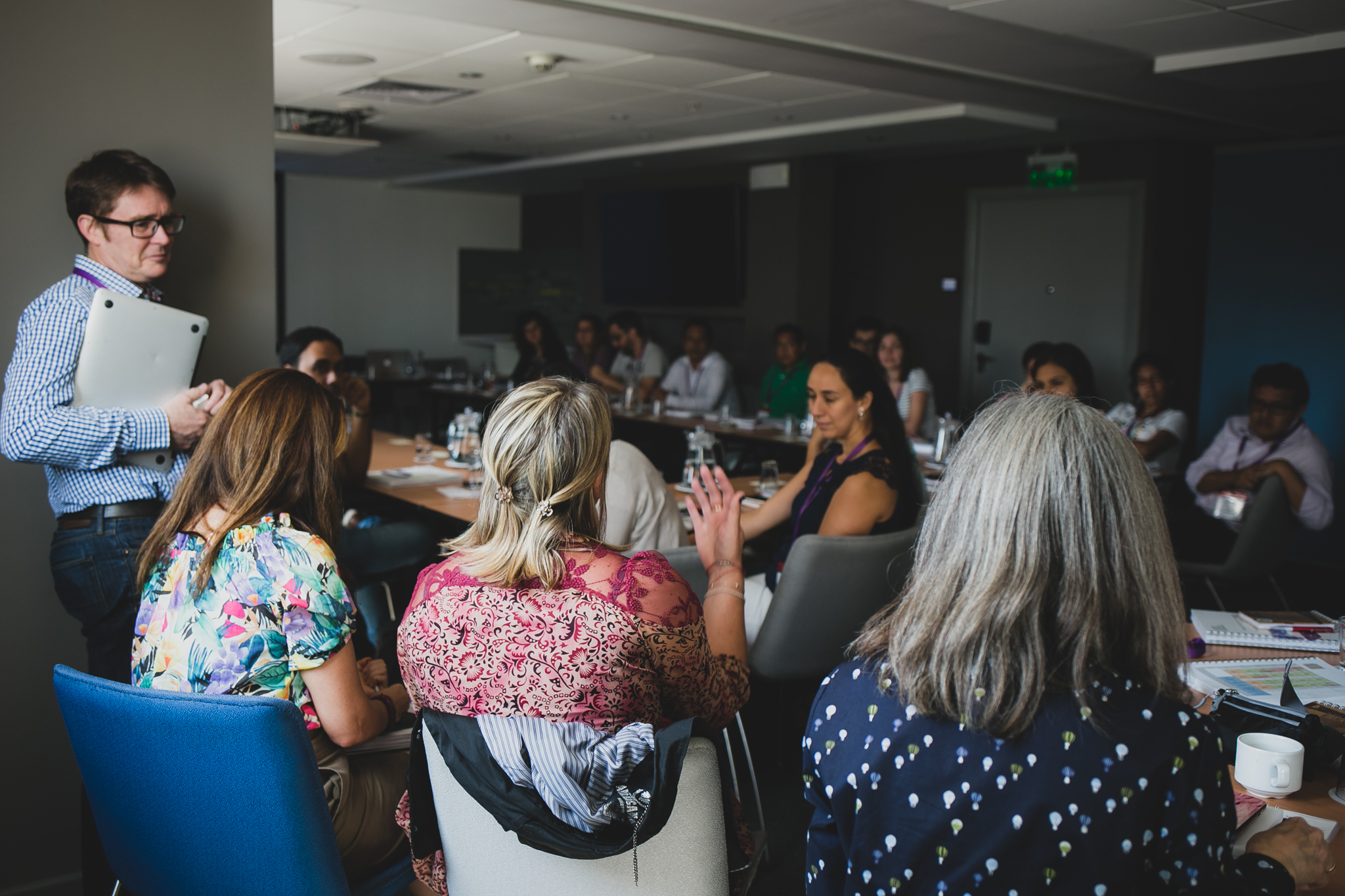 group of learners and instructors debating sitting around connected tables