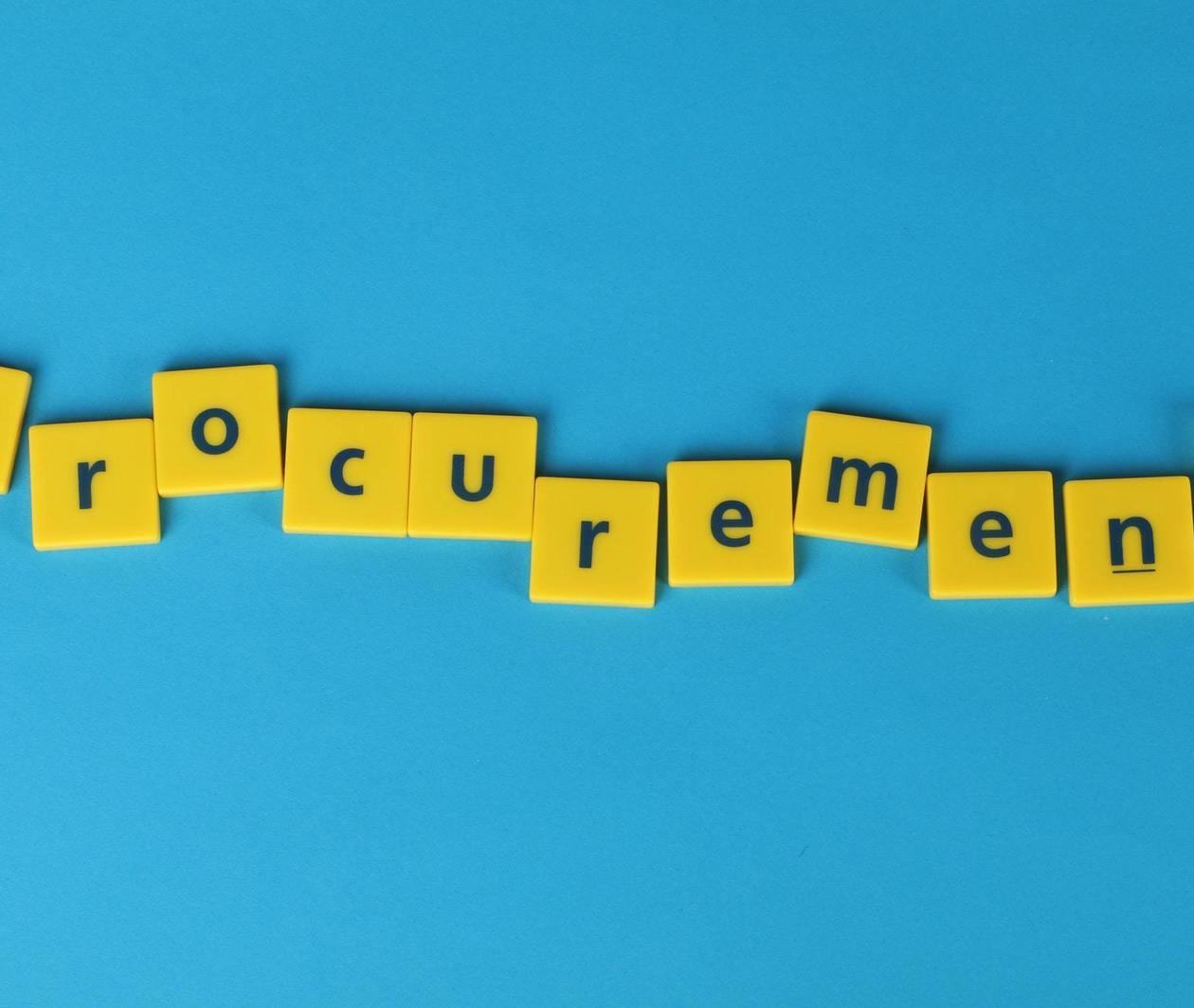 The word procurement spelt in Scrabble tiles.