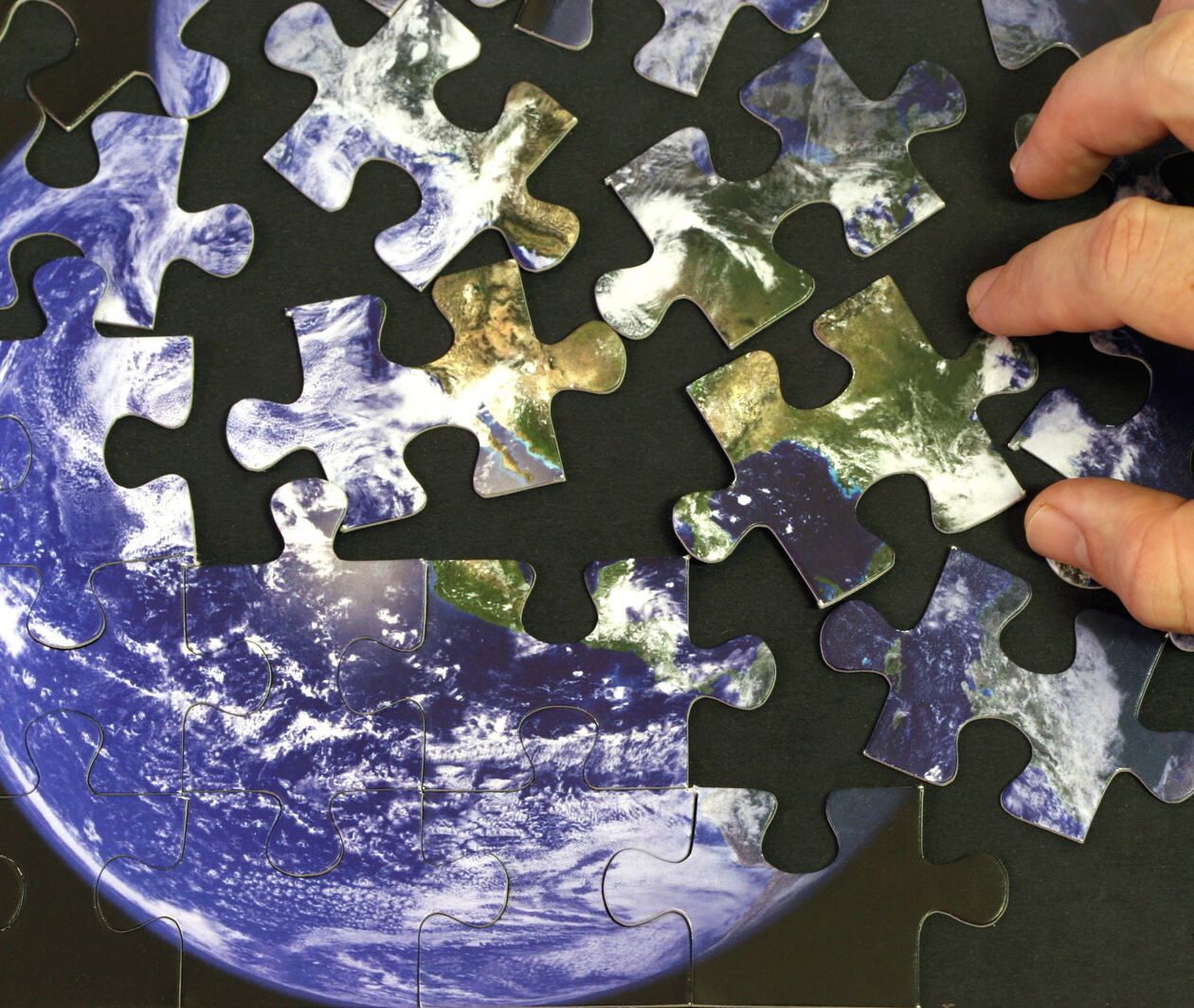 Picture of a person playing with a planet Earth themed jigsaw puzzle.