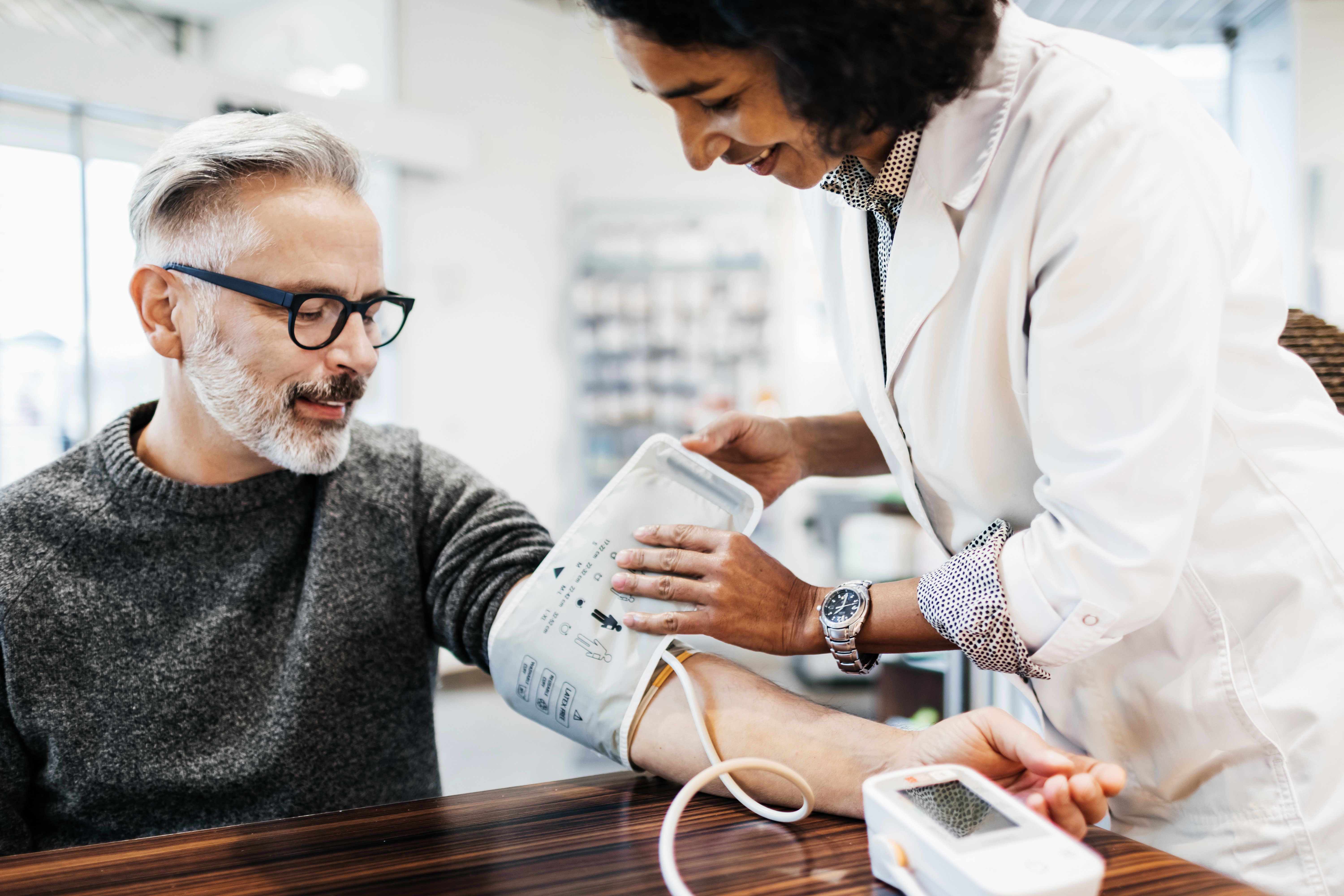 Pharmacist Measuring Mature Man's Blood Pressure.