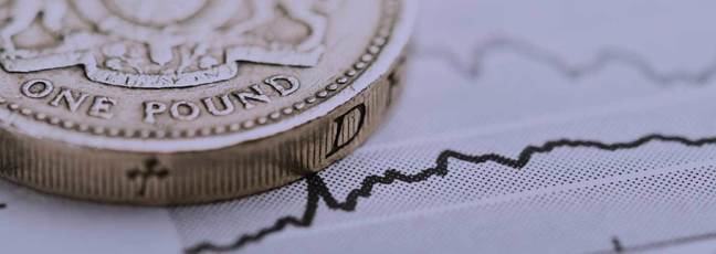 A coin sits on top of a line graph on a piece of paper – a metaphor for financial planning.