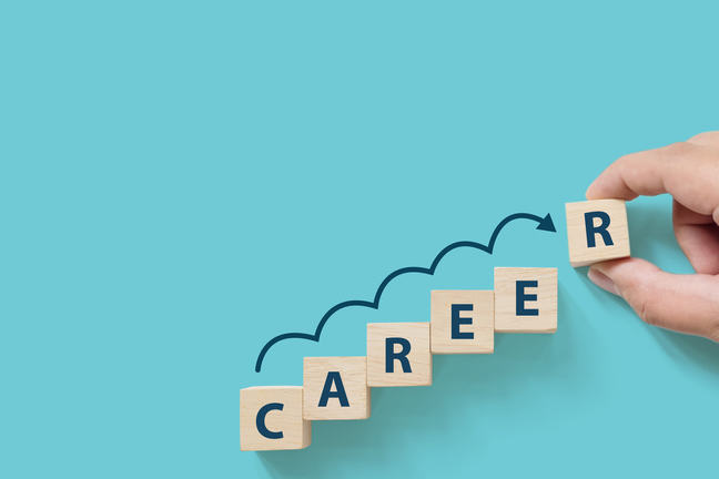 Hand putting wooden cube block on blue background with word CAREER