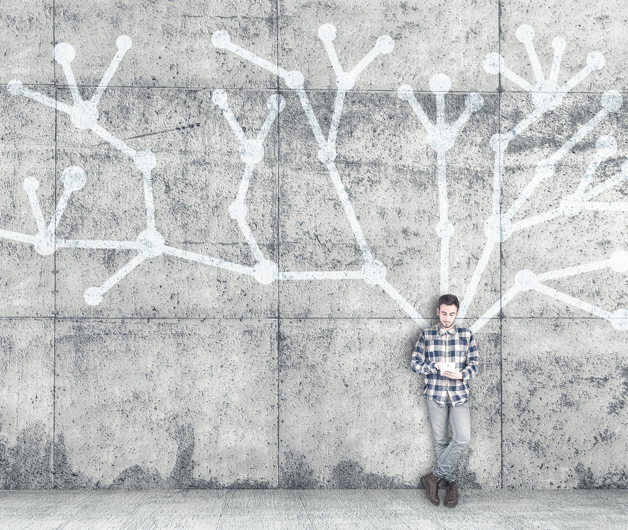 Young autistic man with tablet leaning against wall