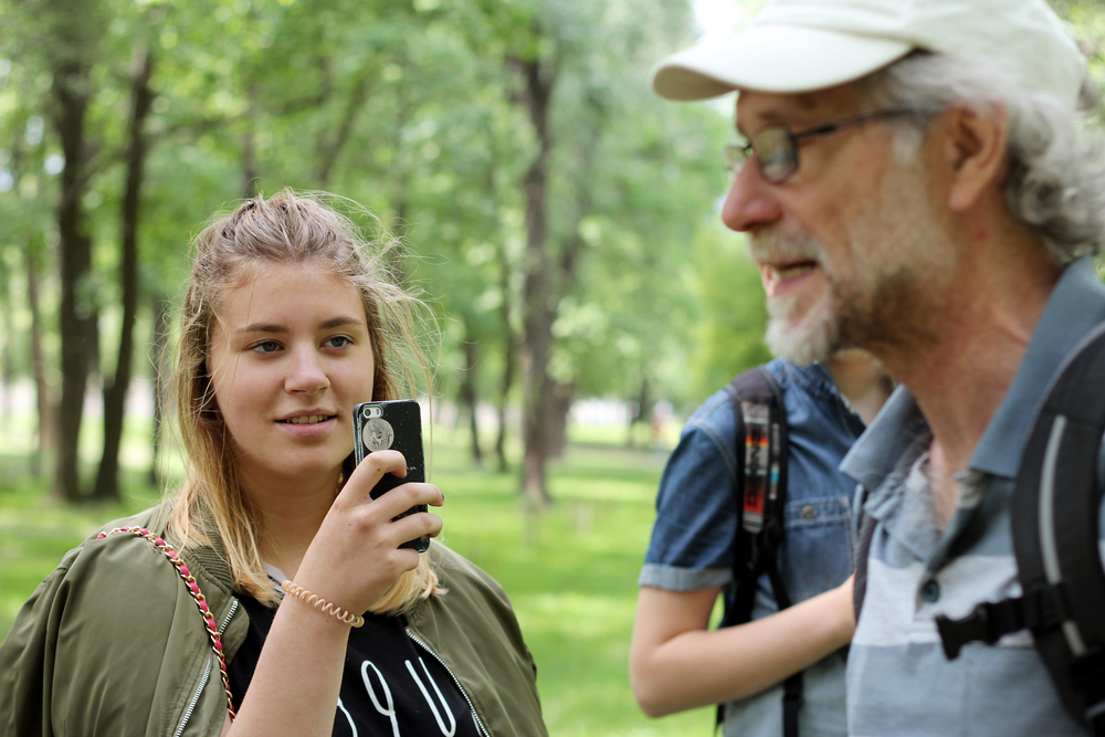 Worman recording an interview with a mobile device