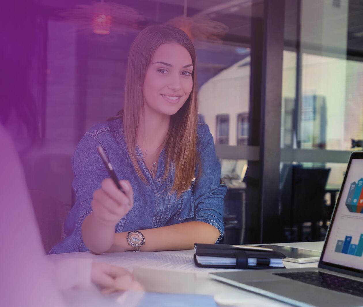 A man and a woman at a desk in an office analysing data. 