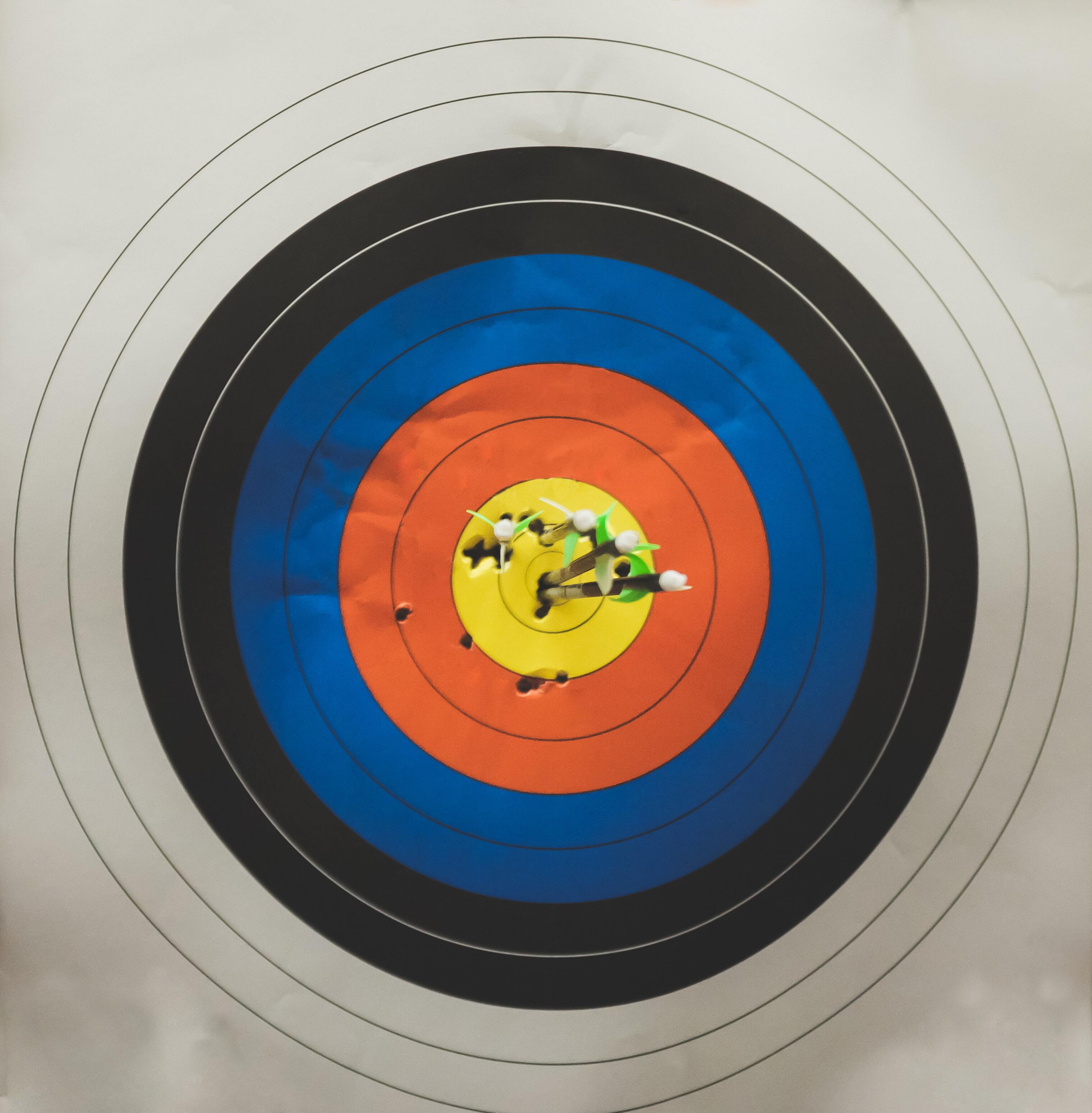 photo of archery target with arrows in the centre