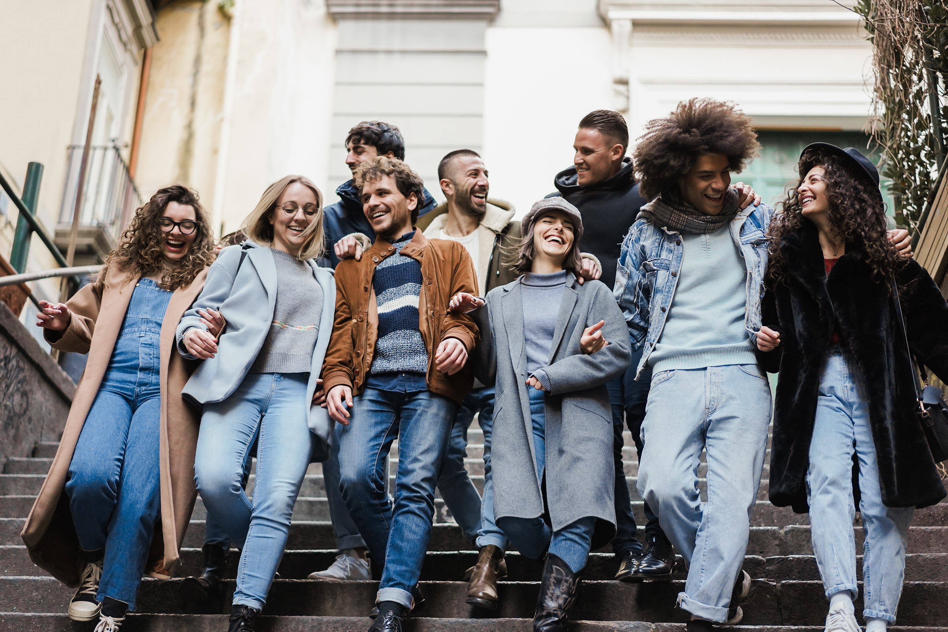 A diverse group of young people walking down some stairs.