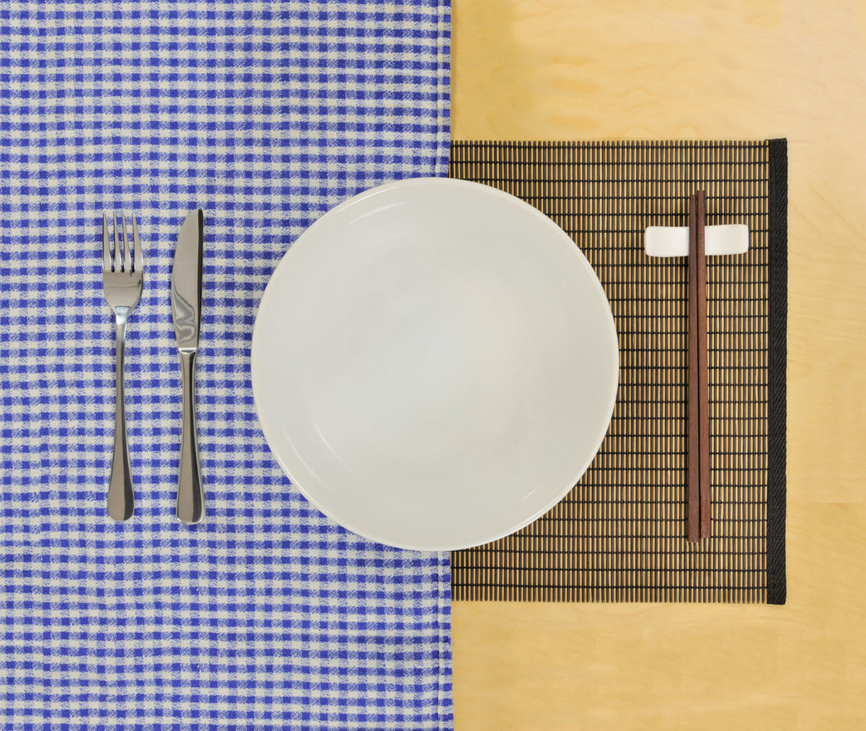 Intercultural communication, symbolised by a plate with a knife and fork on one side, and chop sticks on the other
