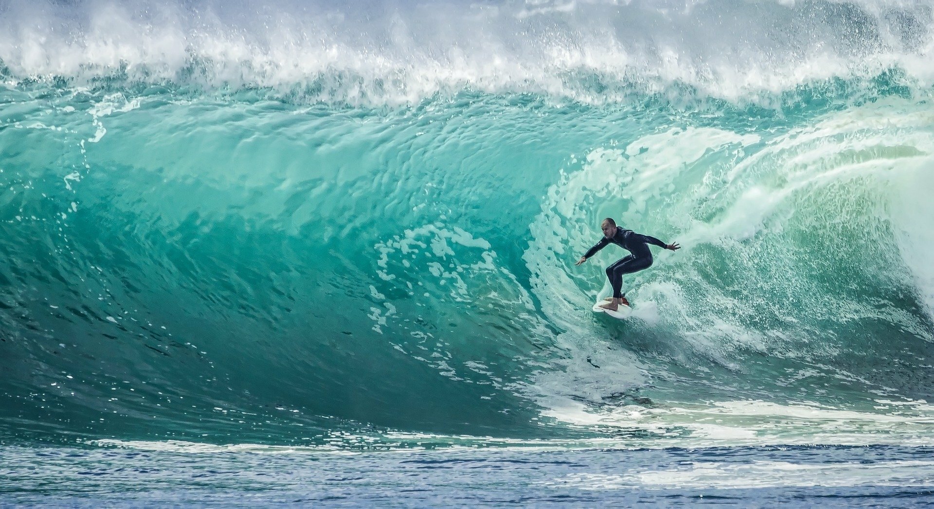 A surfer inside the tube of a large wave.