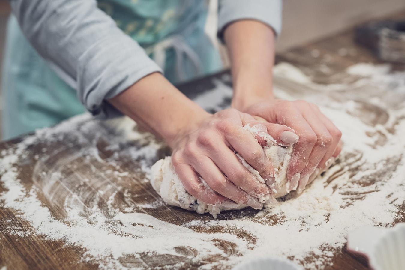 a person standing and making dough