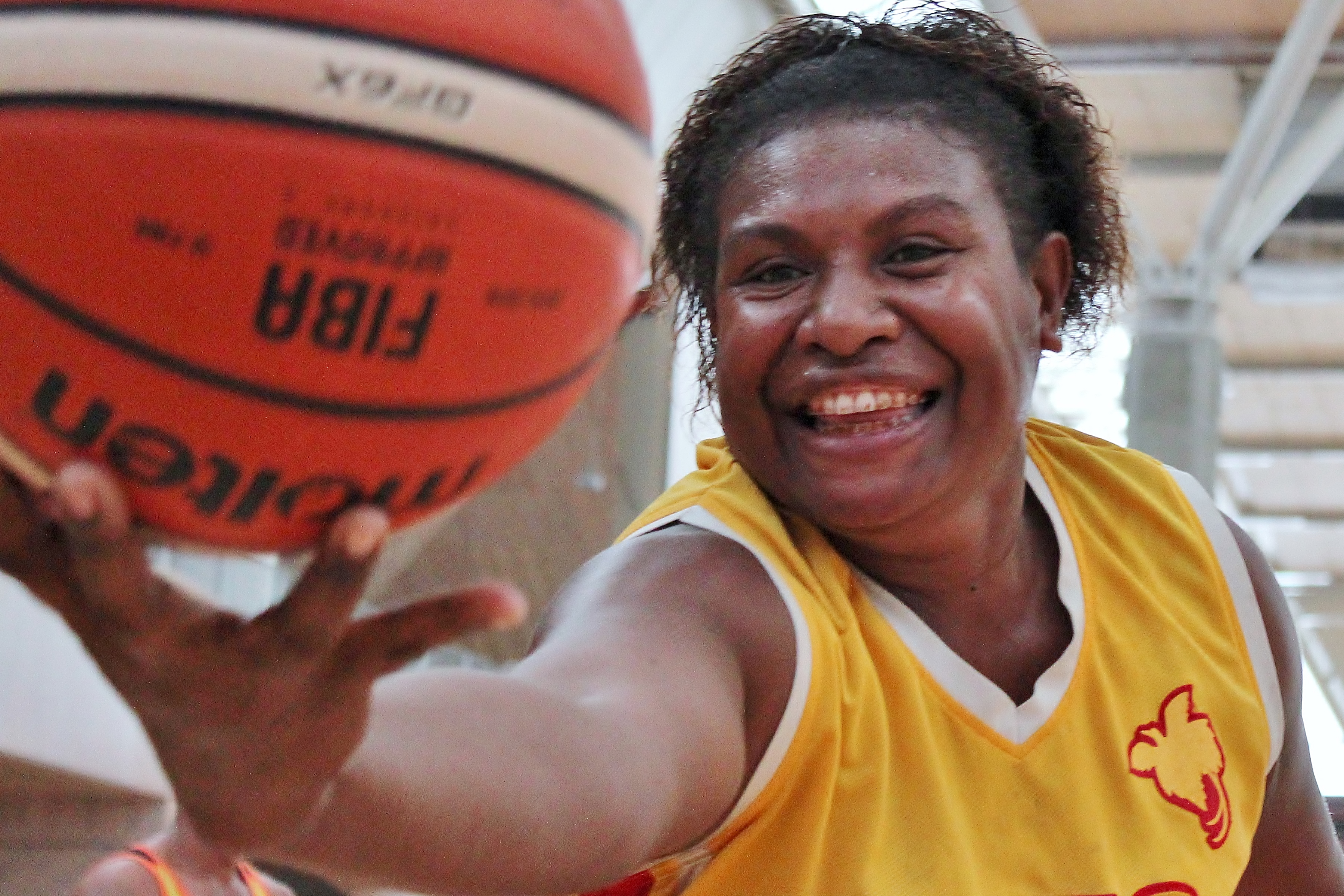 a female coach reaches out with a basketball, Papua New Guinea