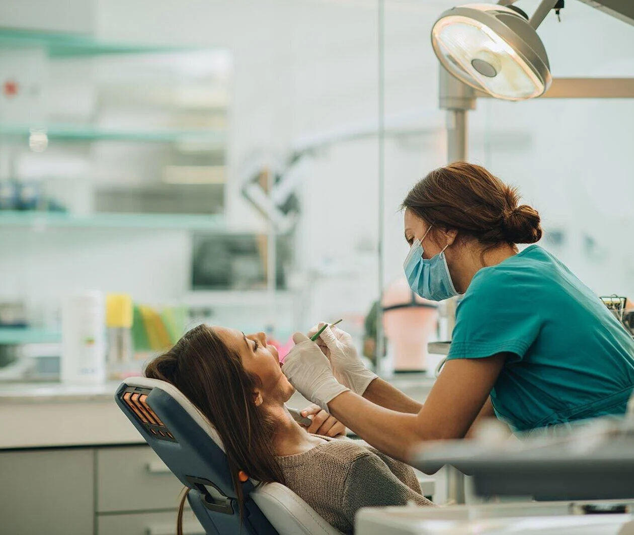 a dentist using instruments to give a woman dental treatment 