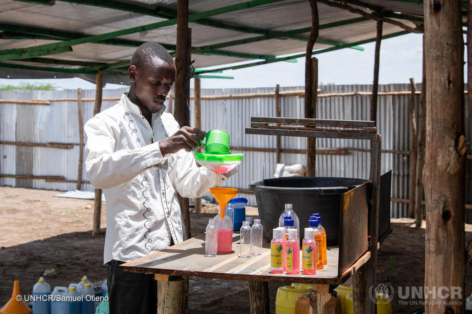 Man, called innocent Havyarimana, a refugee soap maker, is pouring hand sanitiser into smaller bottles.