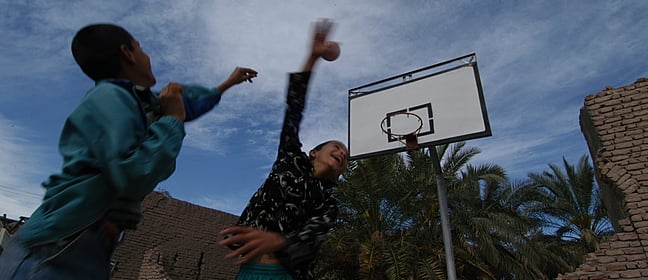 Two children playing basketball.