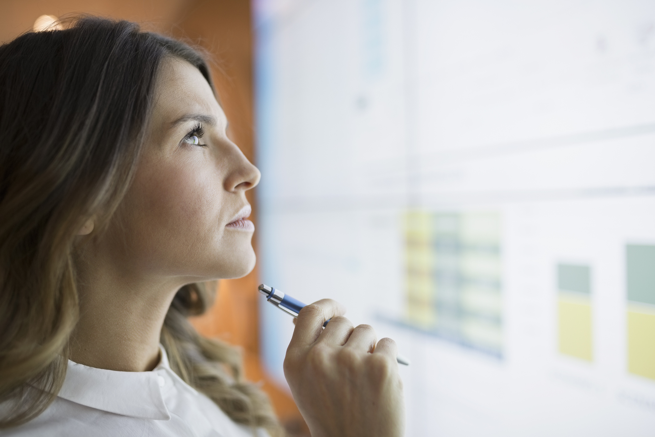 Woman with a pen in hand deciphering data