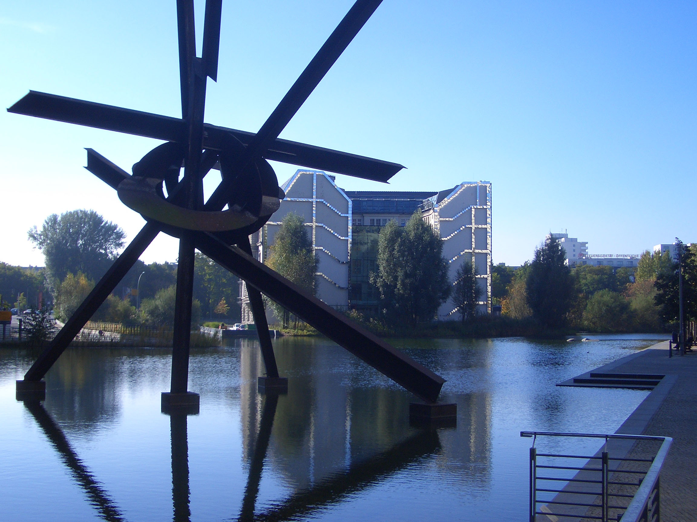 View over water with buildings in the background and art work in foreground