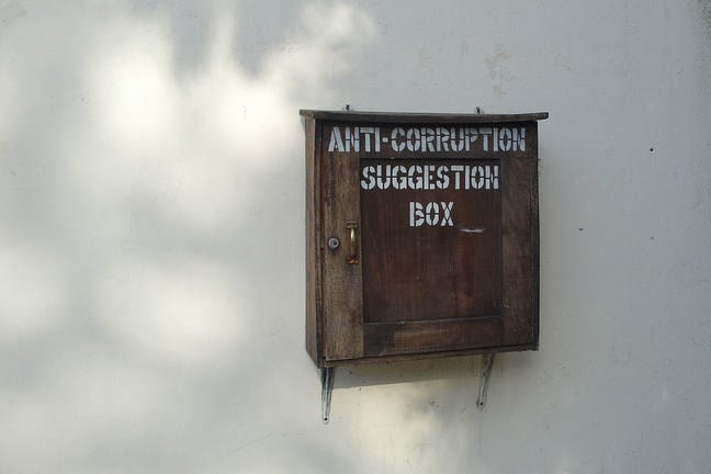 Box on wall with wording Anti corruption suggestion box