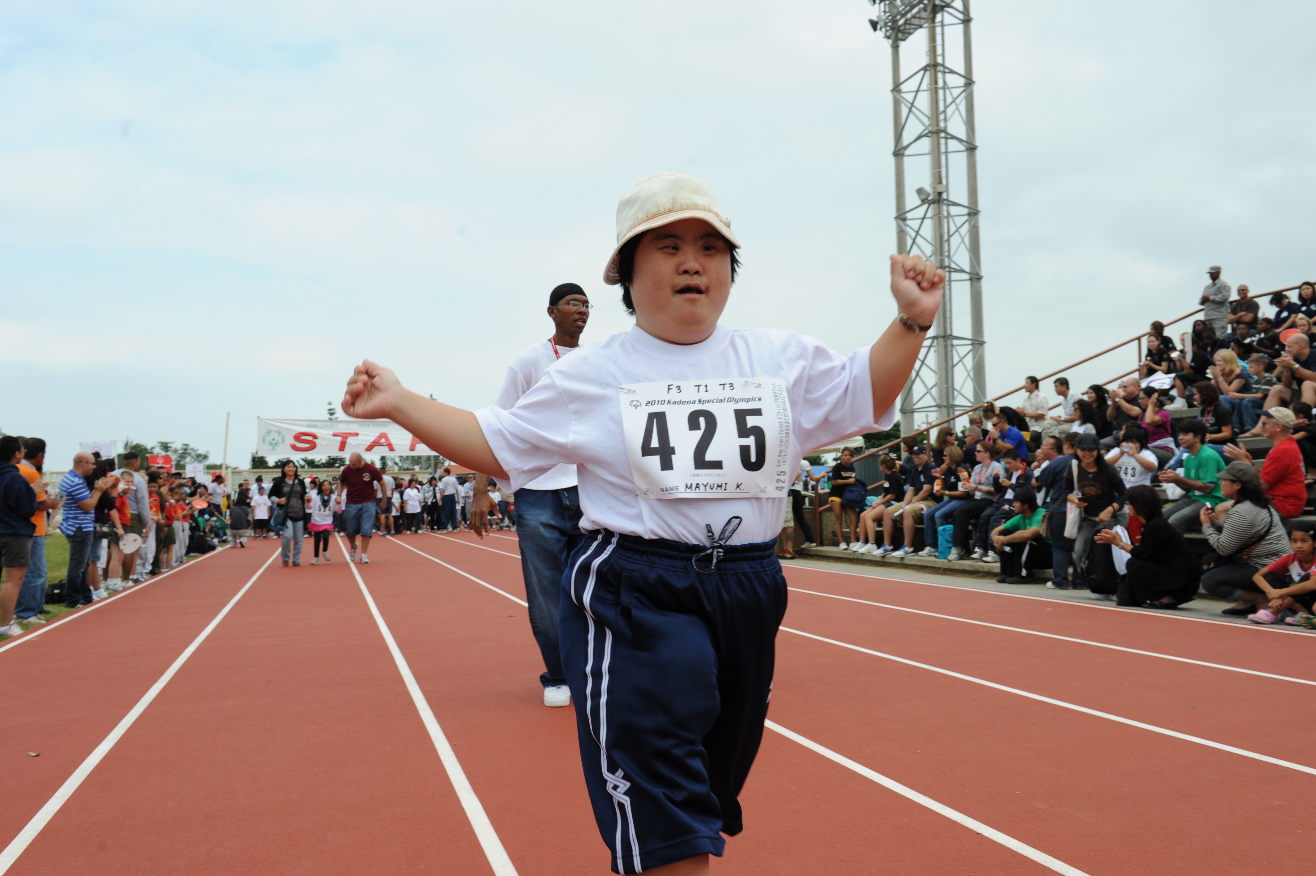 A child with Down Syndrome running in a race.