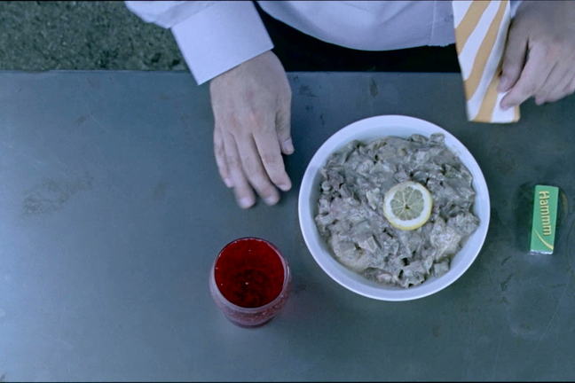 Birds eye view close up shot of a man eating at a cafe from the film Szalontudo