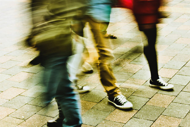 Young adults legs walking past