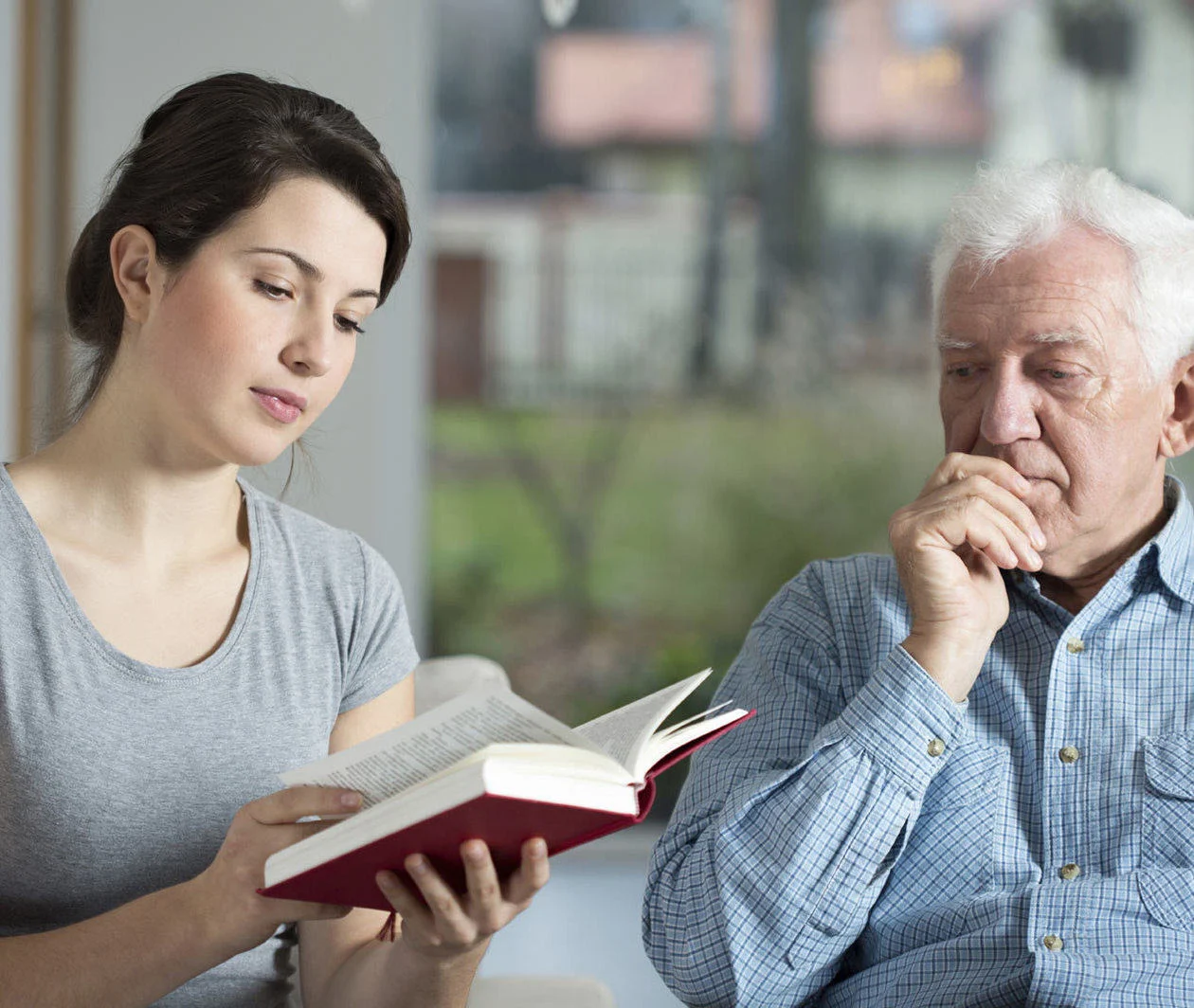 Supporting people living with long-term conditions: a woman reads a book to a man