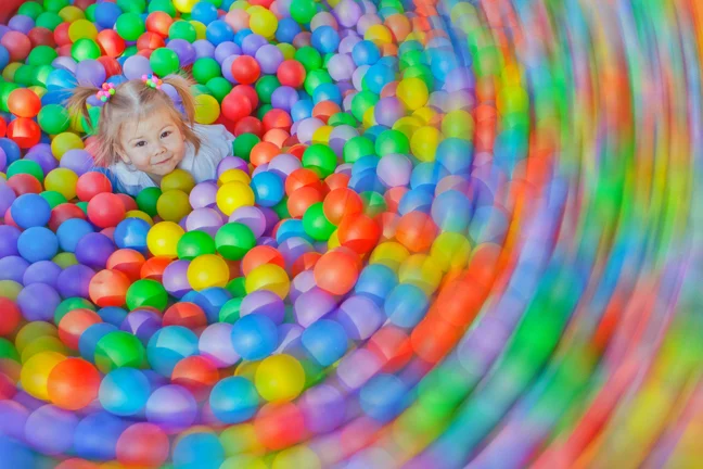 Girl at centre of a ball pool