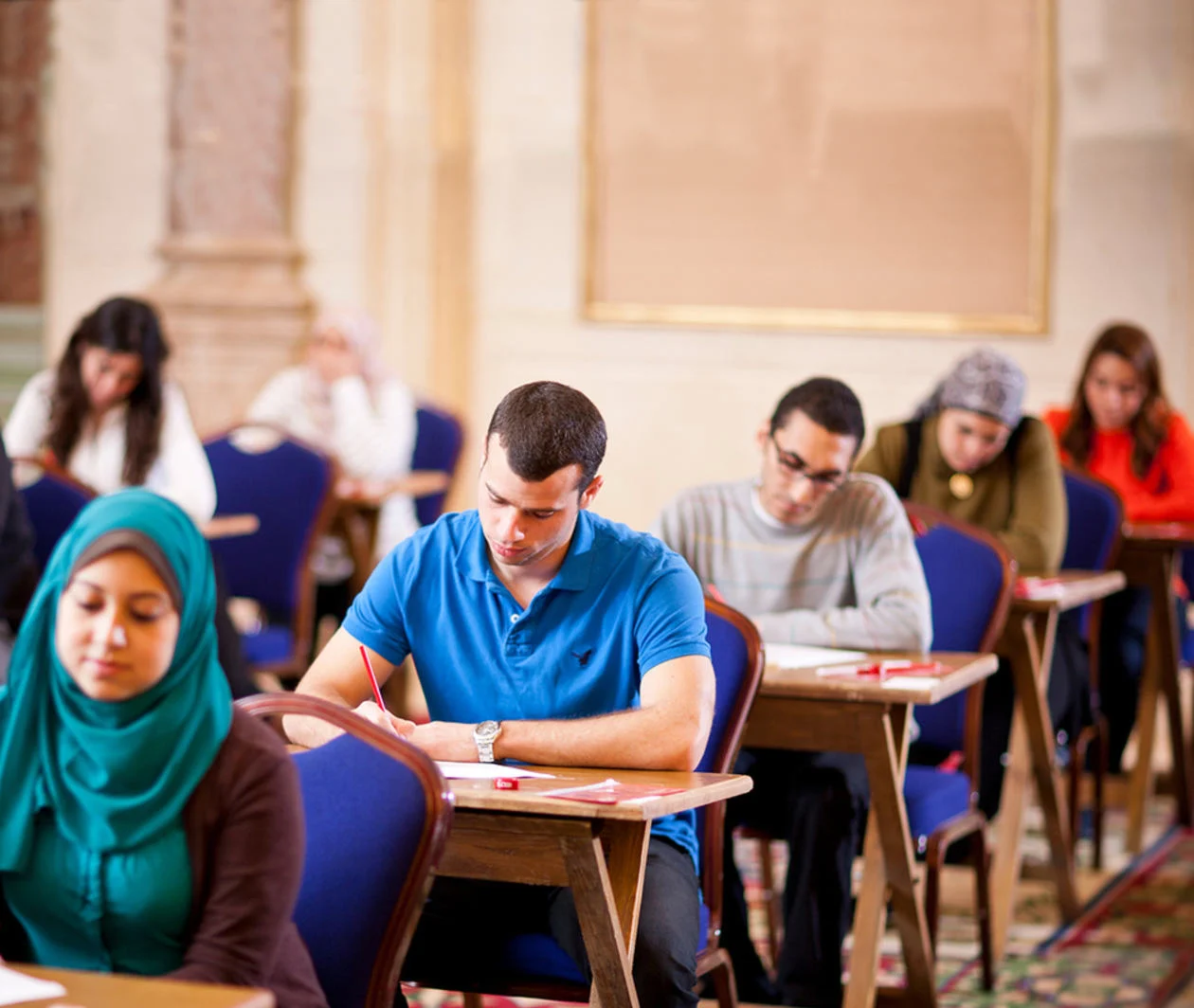 Students sitting at desks in an examination room.