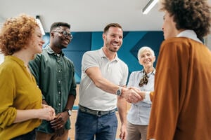 Happy businessman shaking hands with colleague on a meeting in the office.