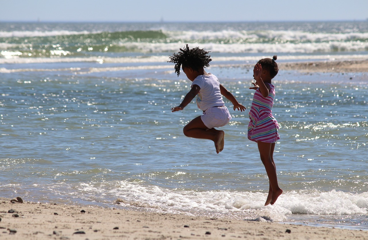 photograph of children jumping in the ocean