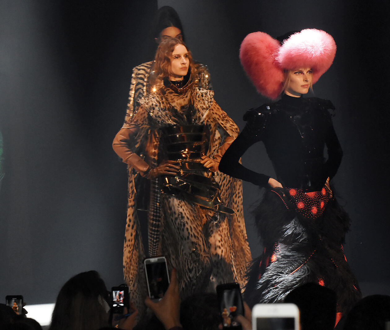 A group of models walk the runway wearing fur garments. 