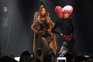 A group of models walk the runway wearing fur garments. 