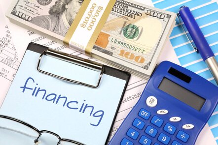 A clipboard with a sheet of paper that has the word financing written on it.
