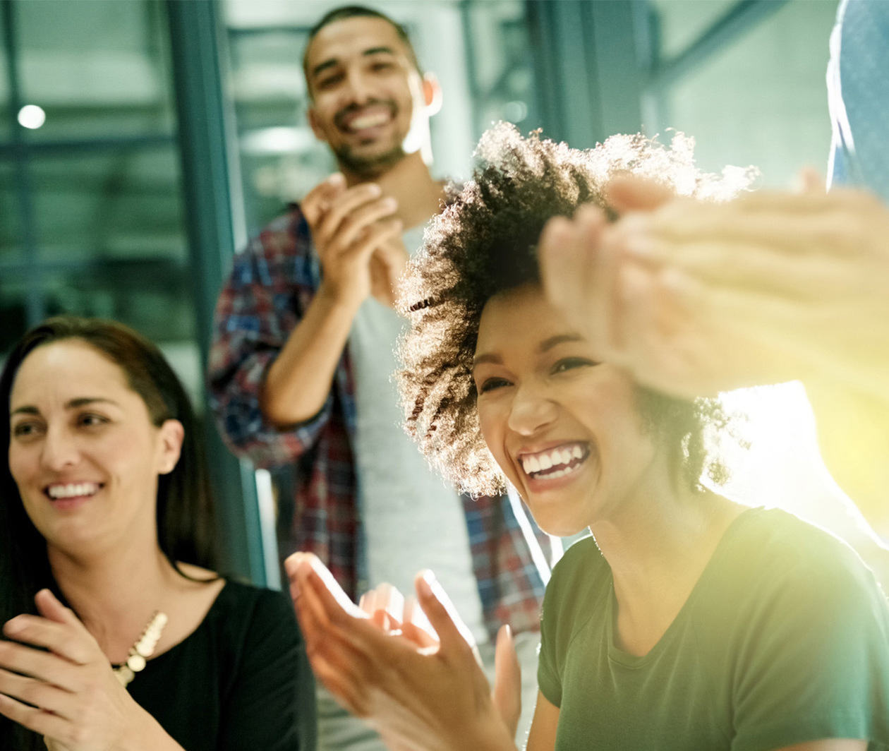 Team of creative businesspeople applauding an achievement while working late in the boardroom