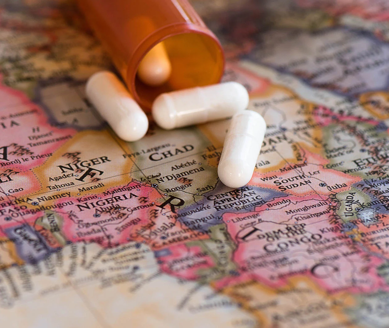 A map of Africa with a bottle of pills on top