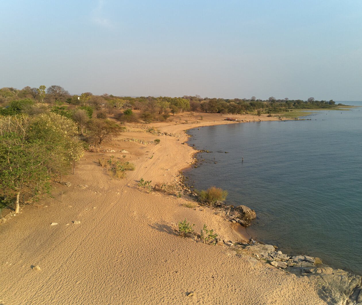 A view across Lake Malawi, with drylands on the left and the lake on the right.