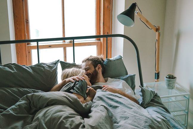 Een man en vrouw liggen in bed samen