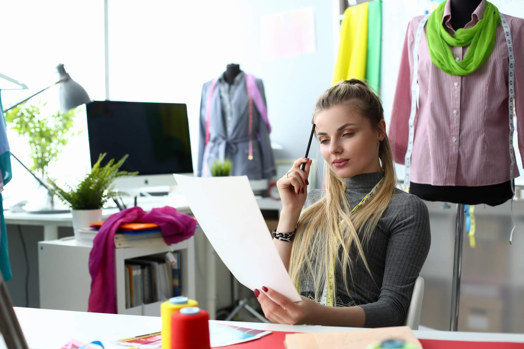 Young female designer contemplates sheet of paper