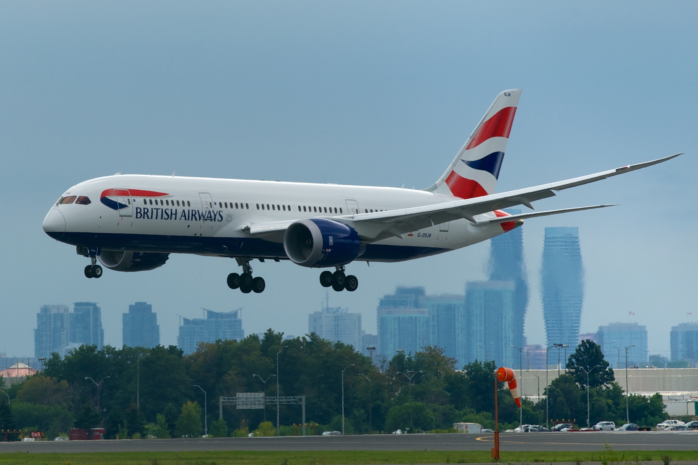 First intercontinental flight of a British Airways Boeing 787-8 about to touch down, Toronto-Pearson Airport with City Centre Mississauga looming in the background.