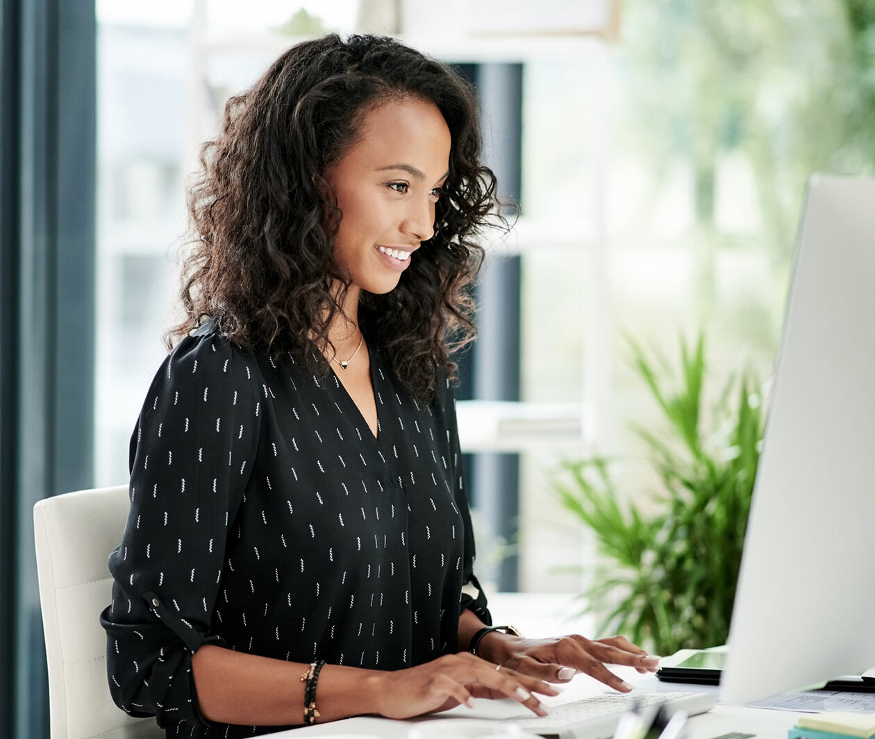 Shot of a young businesswomen using a computer at her desk in a modern office doing web application testing.