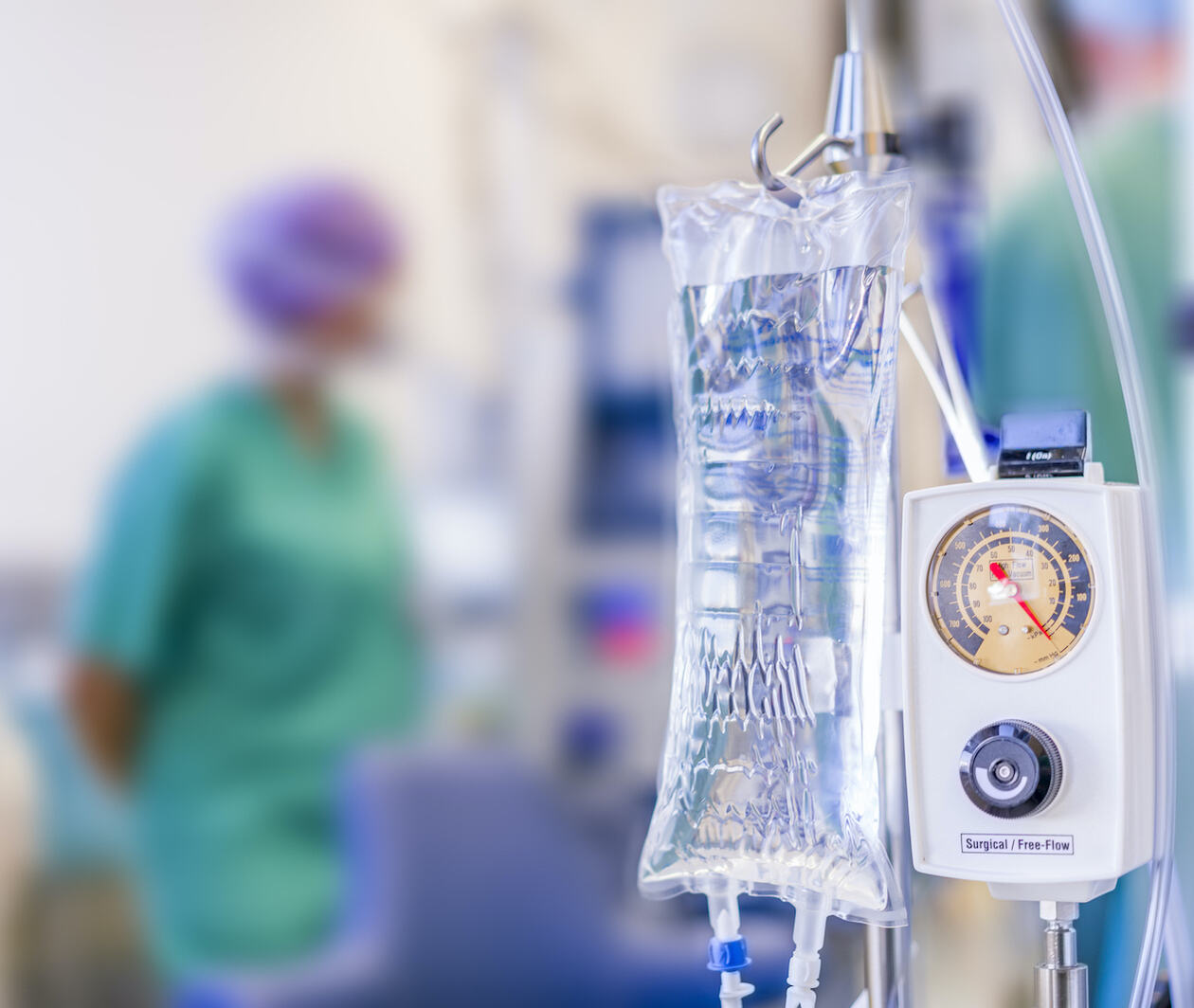 IV bag in the foreground with surgical theatre in the background