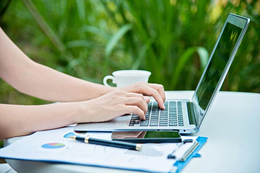 Learner outside working on laptop