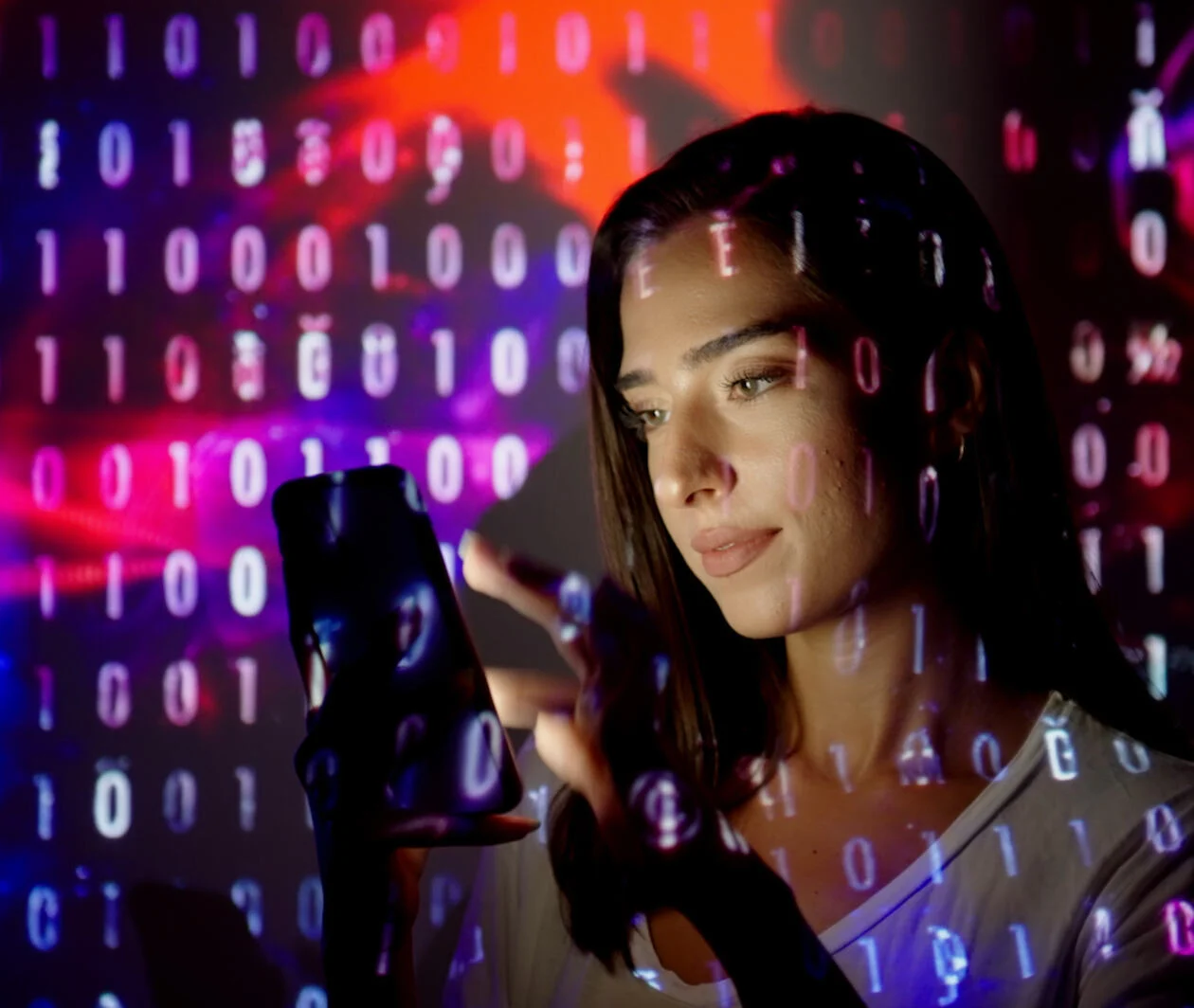 Code projected on a woman using a smart phone.