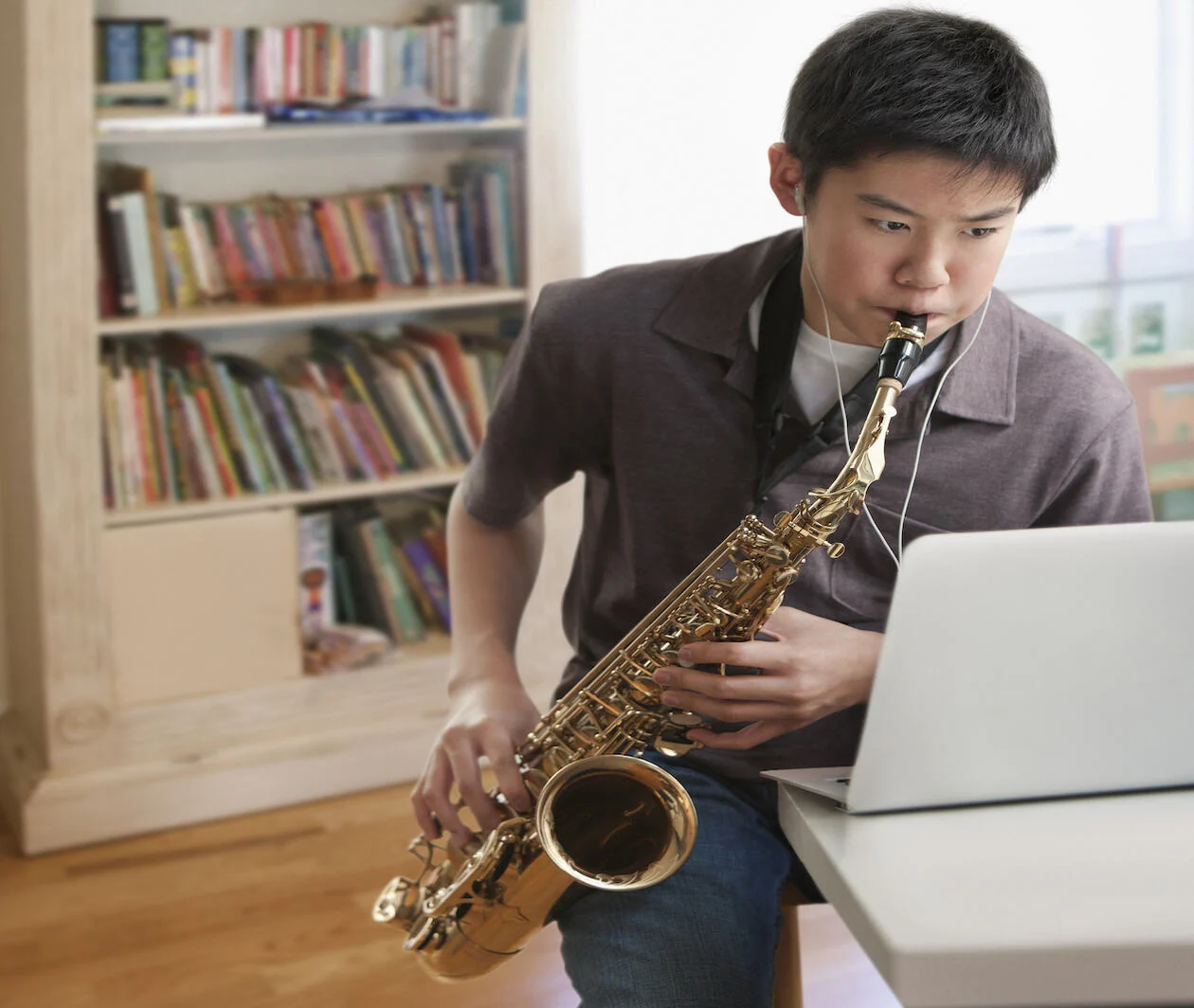 Asian boy playing saxophone 