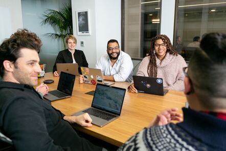 Photo from Mapbox on Unsplash - Co-workers working on an app round a table