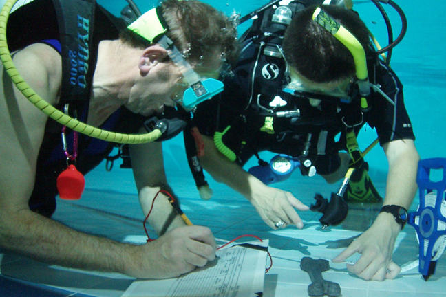 Nautical Archaeology Society trainees learning to recording artefacts underwater.