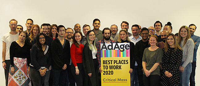 Some of the Critical Mass team holding a sign that reads "Ad Age Best Places to Work 2020"