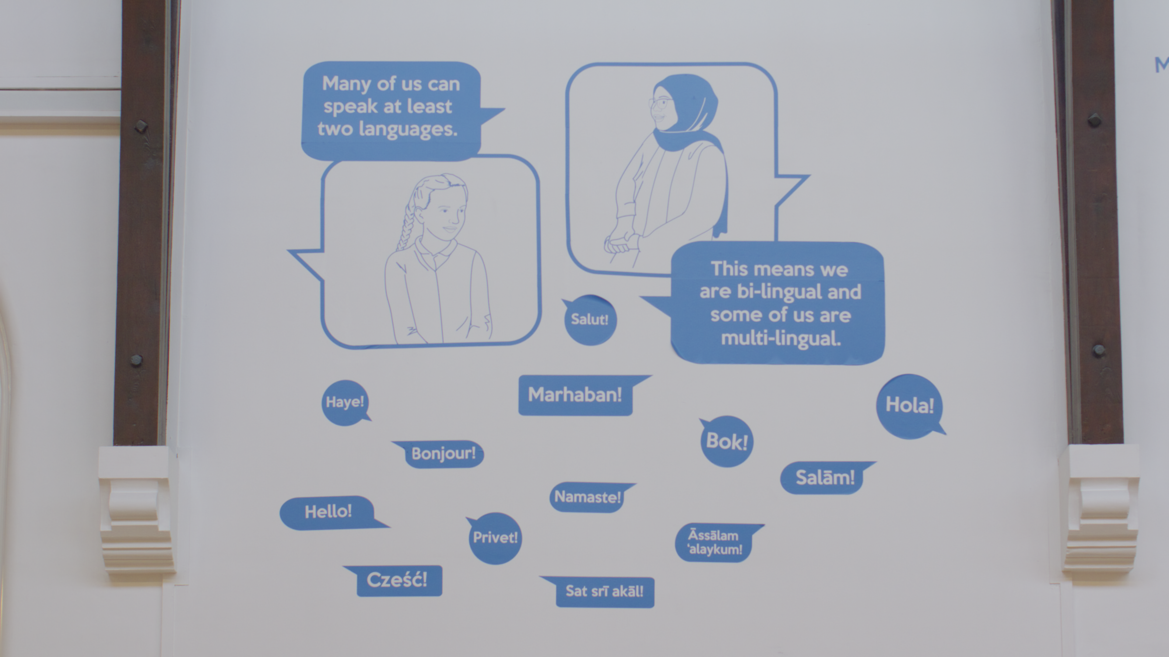 Poster which states many of us can speak at least wo languages. This means we are bi-lingual and some of is are multi-lingual. Then hello in different languages. .