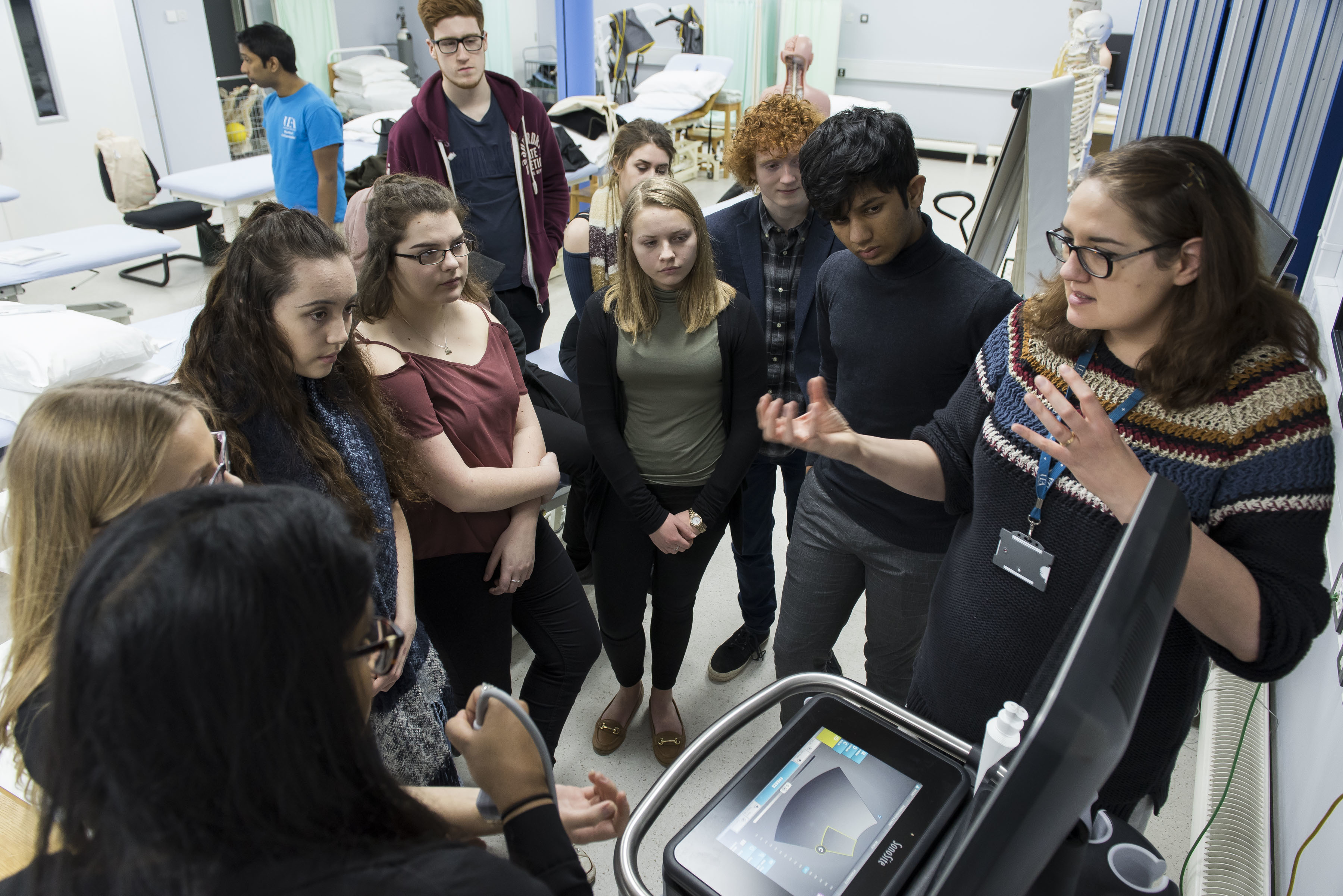 Students gathered around a piece of medical equipment