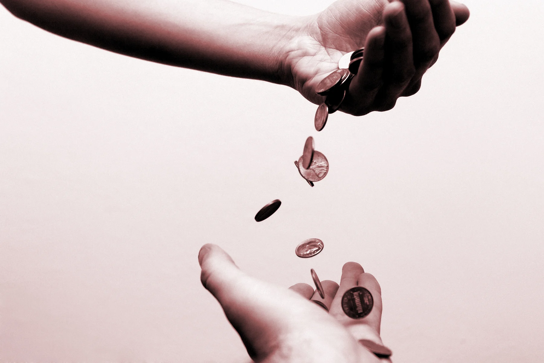 Coins moving from one person's hand, to another's.